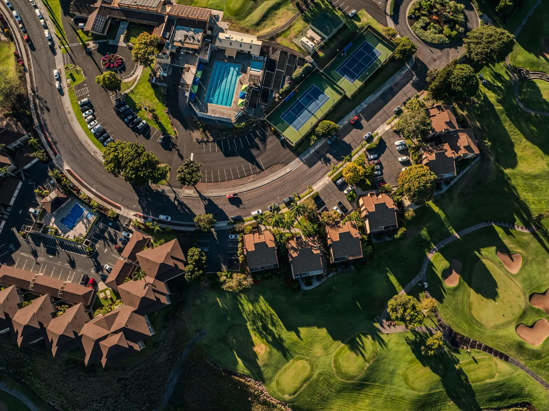 Aerial view of an estate with golf greens, tennis courts and managed lawns