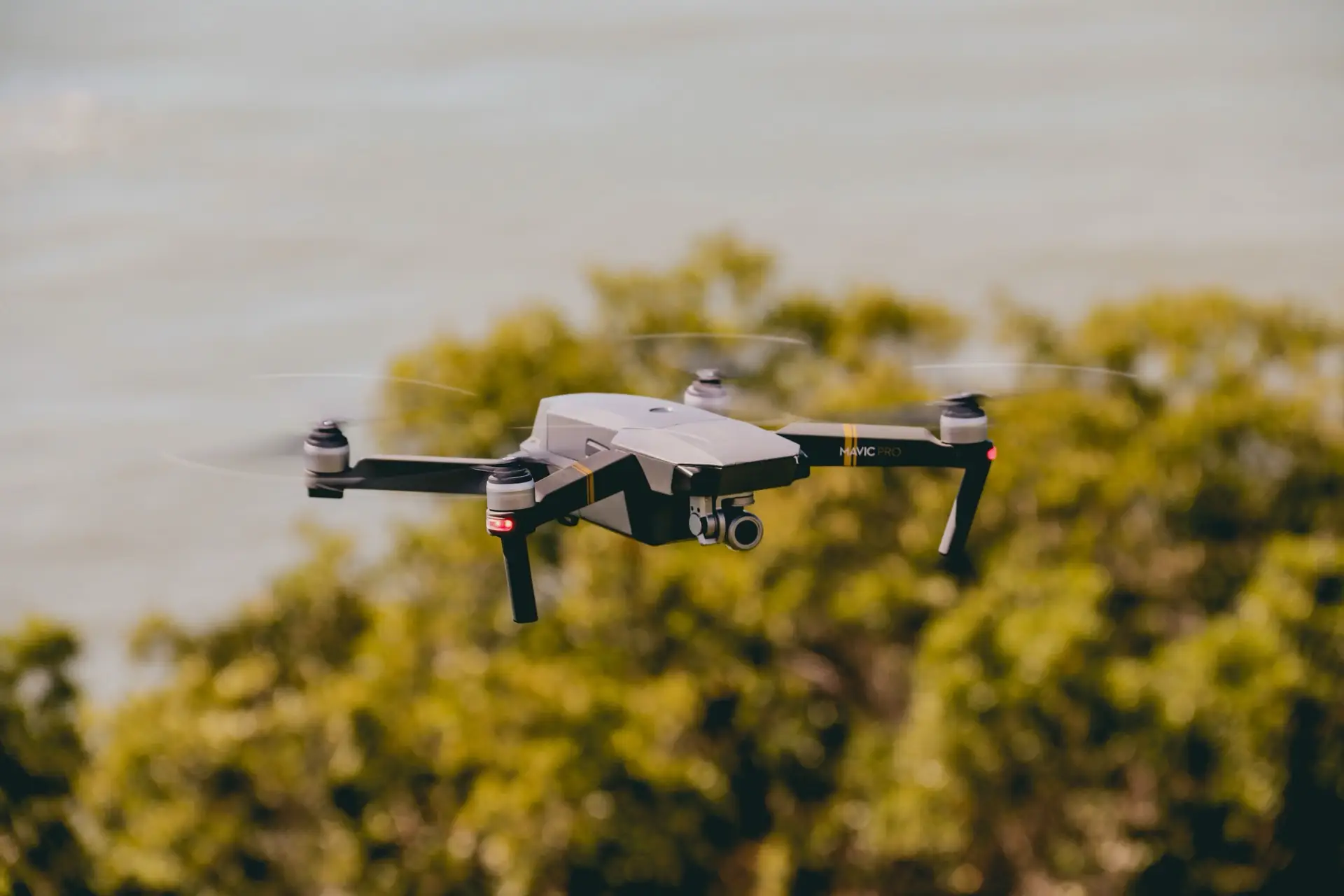 A survey drone in flight over coastal vegetation